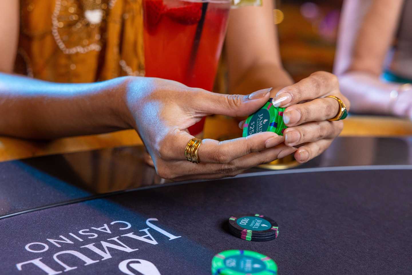 A closeup of a visitor's hands holding poker chips and having fun playing games in Jamul Casino Resort.